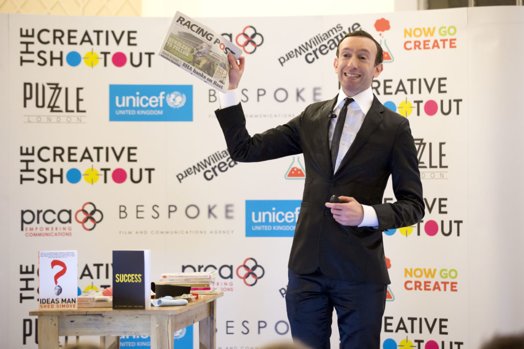 The Creative Shootout presentation with a man in suits holding a newspapers in his right hand