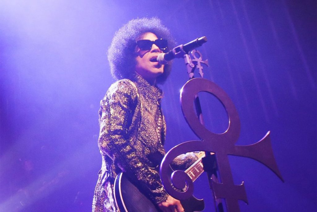 Prince on stage with Prince symbol